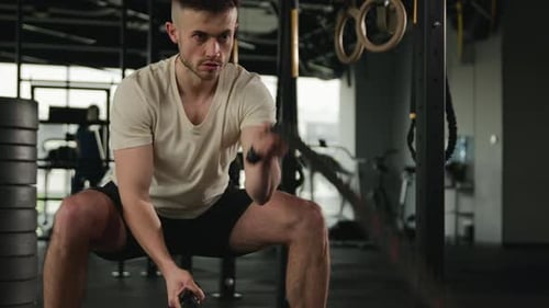 Man Works Out With Battle Ropes in Gym