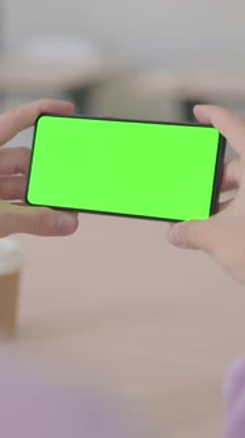 Rear View of Man Holding Smartphone with Green Chroma Screen, Vertical Video