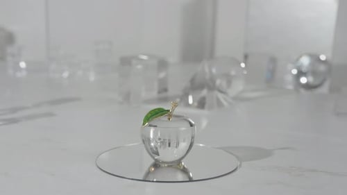 Crystal Glass apple on top of a mirror shinning light through