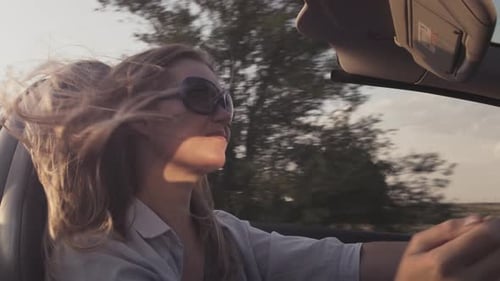 Junges schönes Mädchen fährt im Sommer einen Cabrio-Sportwagen