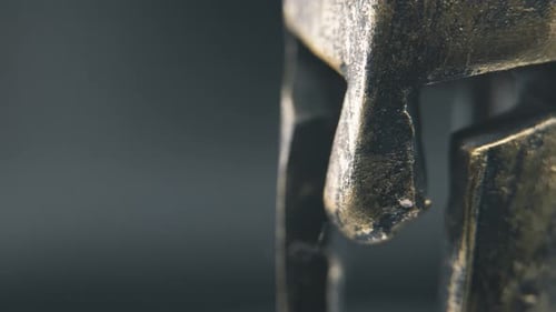 A close up detailed slow pan right shot of a spartan face design, warrior ancient greek bronze helme