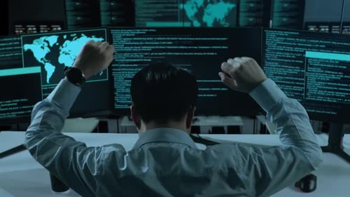 Happy Asian Man Celebrating And Dancing While Write Code With Multiple Computer Screens In office