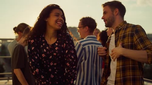 Cheerful Friends Dancing Together on Rooftop at Sunset