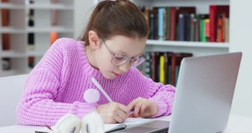 Focused Child Studies with Laptop in Library