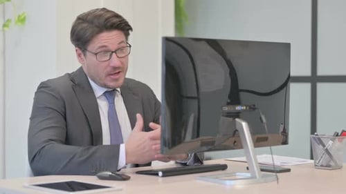 Business Man Talking at Computer in Office