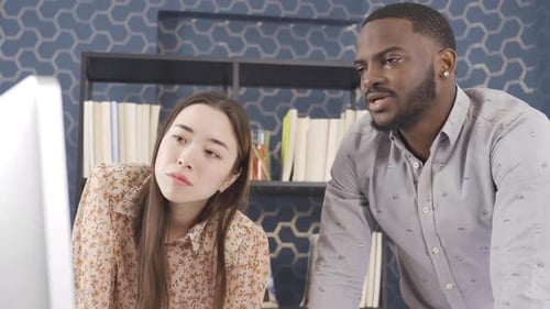 Multiethnic teamwork, african man and asian woman working in office.