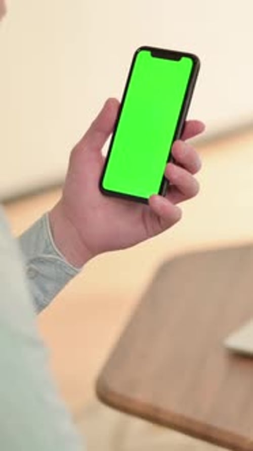 Man Holds Phone with Green Screen for Mockup