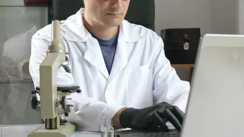 Au Ralenti, un homme vêtu d'une blouse blanche et de lunettes examine attentivement l'objet d'un annélide dans un