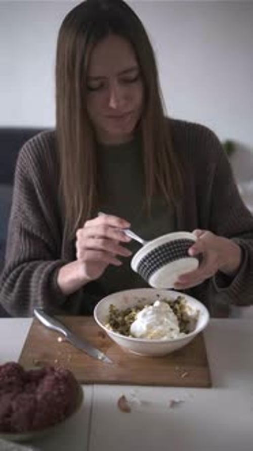 Woman Adds Sour Cream to Salad in Bowl Preparing Delicious Homemade Meal Indoors