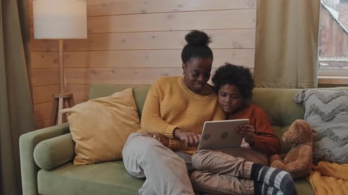 Mother and Child Enjoying Tablet on Couch