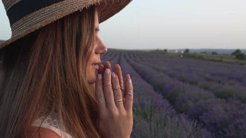 Femme au chapeau de paille contemplant un champ de lavande