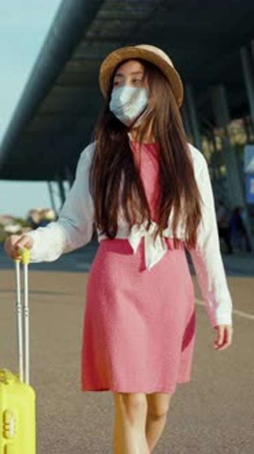 A Stylish Traveler with Bright Yellow Luggage Moving Gracefully Through the Airport