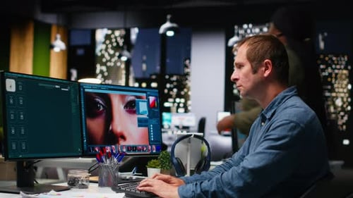 Man Editing Photos on Dual Computer Monitors
