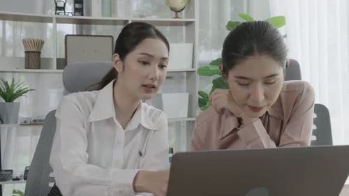 Two Young Enthusiastic Businesswoman Working Together in the Office Workspace