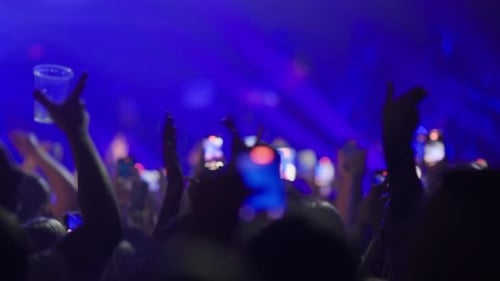 Blurred Crowd Enjoying Concert with Phones and Lights