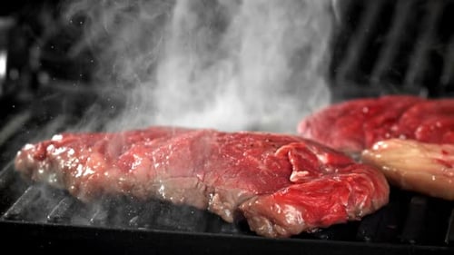 Raw Steak Sizzling on a Grill