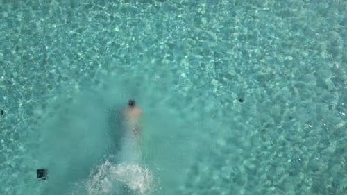 Top View of Man Diving Into the Pool on a Sunny Summer Day