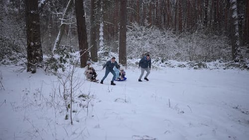Parents and Children Having Fun in the Snow in Winter Winter Holidays Recreation Sledding Concept