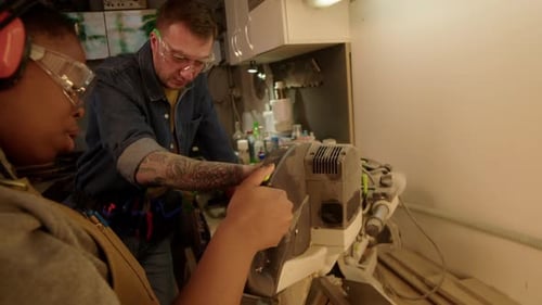 People Operating Industrial Equipment in Workshop