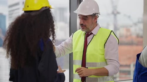 Engenheiros usando o plano de projeto, discutindo e trabalhando