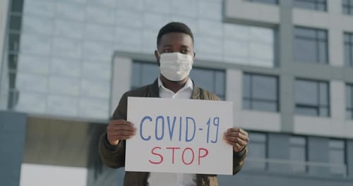 Slow Motion Portrait of African American Man Wearing Medical Face Mask Walking in City Street
