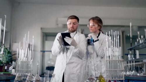 Scientists Examine Data on Tablet in Laboratory Setting