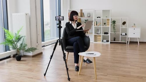 Professional Businesswoman Recording Video Content While Using Laptop in Office