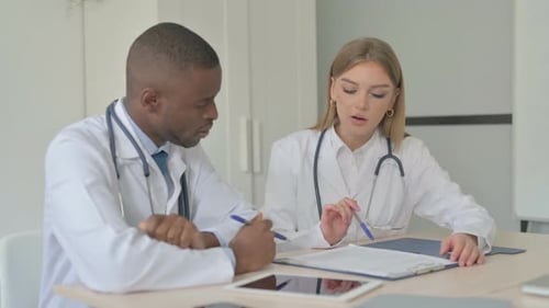 Doctors Collaborating on Medical Records in Hospital