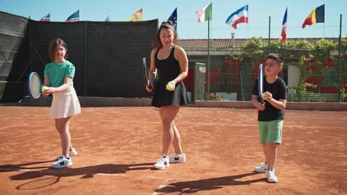 Tennis Coach Teaching Children on Clay Court