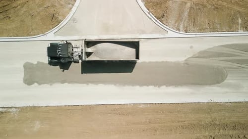 Construction Truck Tipping Dumping Gravel on Road Construction Site Aerial Top Footage