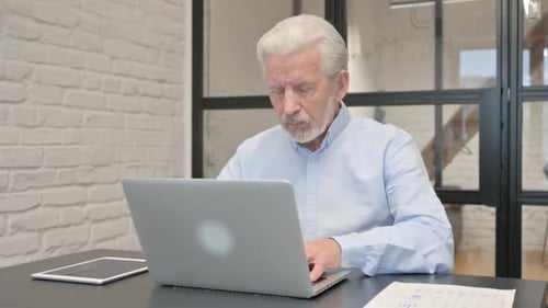 Stressed Senior Man Working on Laptop