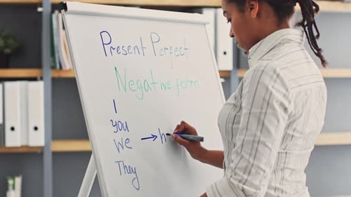 Female Writes Grammar Lesson on Whiteboard