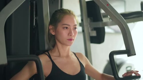 Woman Using Chest Press Machine at Gym