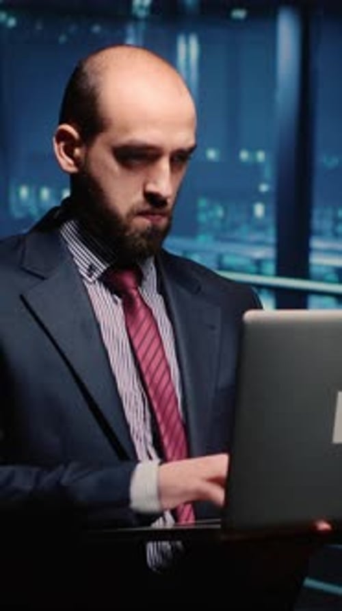 Man Works Late with Laptop in Modern Office