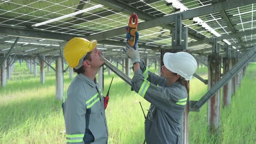 Ein Team von Elektroingenieuren inspiziert und wartet Sonnenkollektoren an einem Standort für Solarmodule.