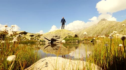 Person Standing on Rock Near Mountain Lake