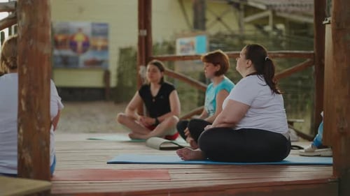 Ejercicio de yoga para relajación, clase de acondicionamiento físico grupal para mujeres con sobrepeso y personas delgadas que entrenan