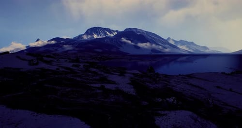 Breathtaking Mountain Landscape with Clouds Near a Tranquil Lake at Dusk
