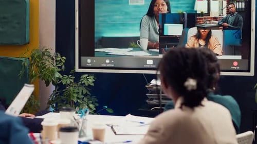 Colleagues Meeting With Remote Team on Interactive Display