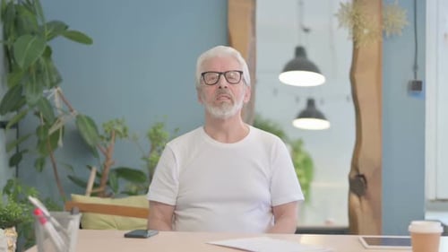 Old Man Talking on Video Call in Office