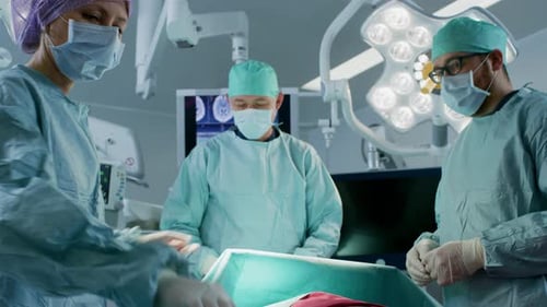 Diverse Team of Professional Surgeons Performing Invasive Surgery on a Patient in the Hospital Oper