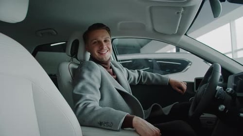 Man Sitting in Car Smiling at Camera