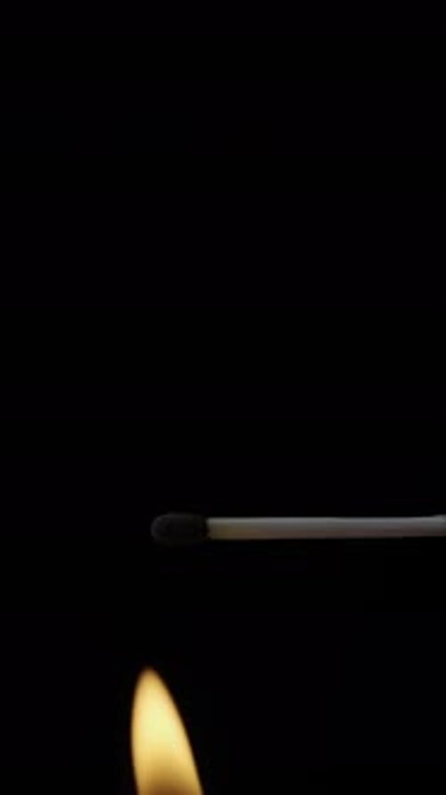 Matchstick Burns Brightly Against Black Background
