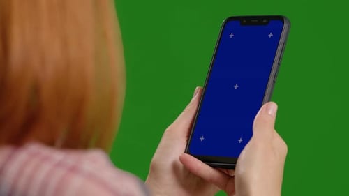 Close up shot of woman studying on blue mock up screen on green screen background.