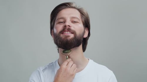Man Using Jade Roller on Neck for Skincare