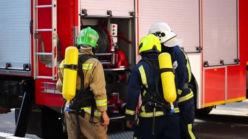 Firefighters Gear Up at Fire Truck in Daylight
