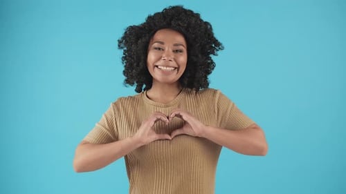 Smiling Woman Making Heart Shape with Hands