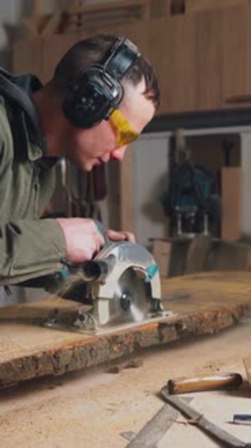 Man Using Power Saw to Cut Wood