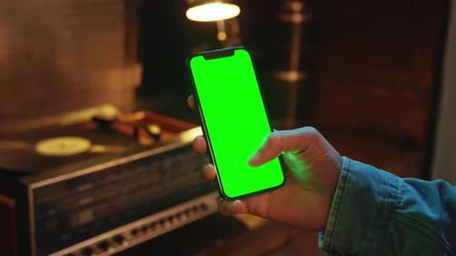 Shot of Hands Man Using Scrolling Mobile Phone with a Vertical Green Screen Indoors Social Media