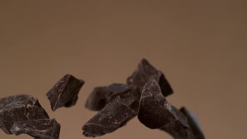 Chunks of rich dark chocolate floating in studio